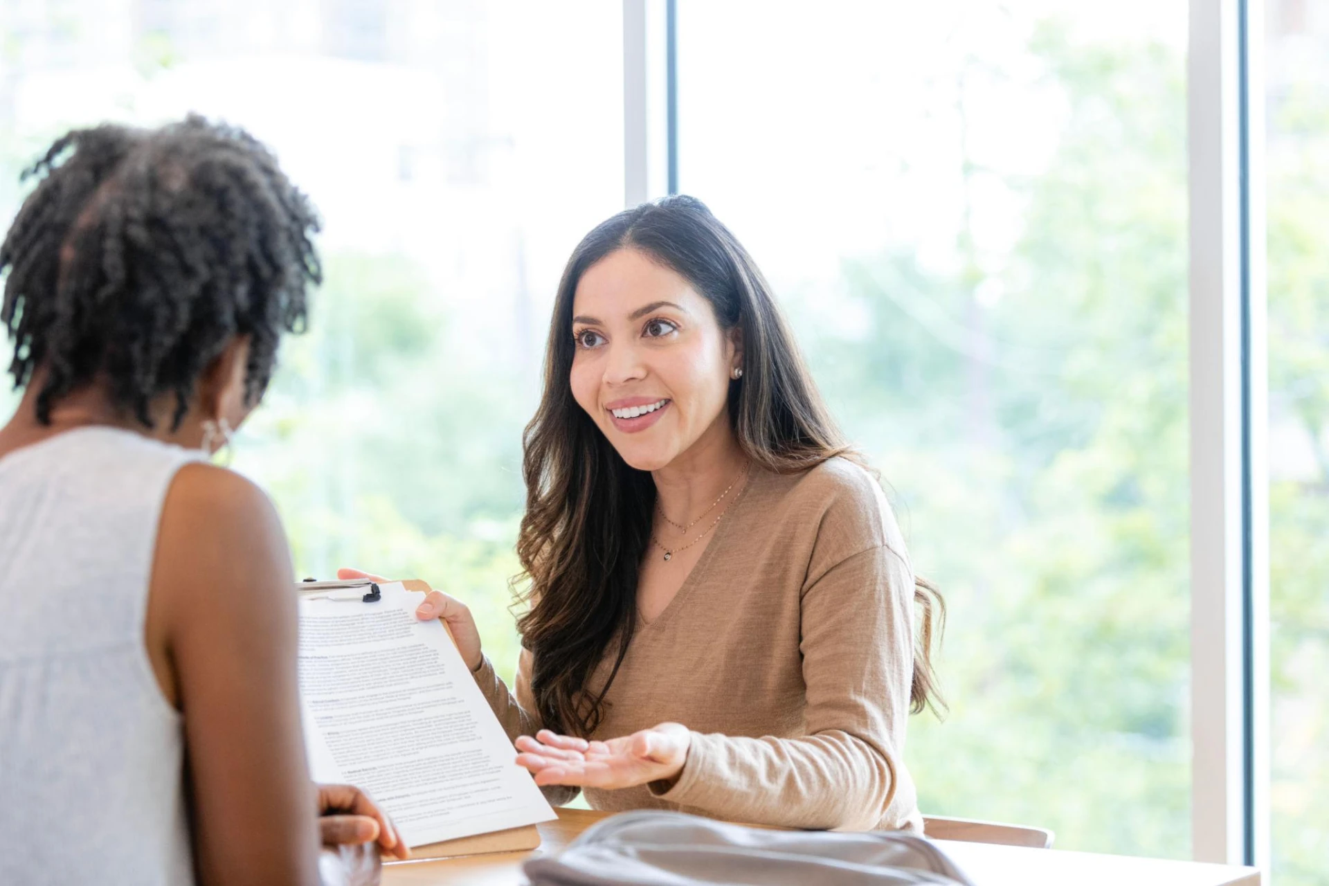 Two professional women in conversation about joining a therapy practice